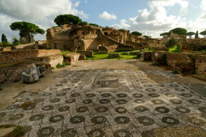 Le rovine delle Terme dei Sette Sapienti a Ostia Antica mostrano un grande pavimento in mosaico bianco e nero e strutture in mattoni romani del II secolo d.C