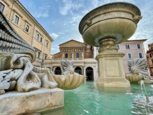 La foto mostra la Fontana di piazza Santa Maria in Trastevere e l'omonima Basilica nel cuore di Roma. Considerata la più antica fontana di Roma ancora funzionante, risale originariamente all'VIII secolo. Fu ridisegnata da Donato Bramante nel Rinascimento e in seguito perfezionata da Gian Lorenzo Bernini e Carlo Fontana.